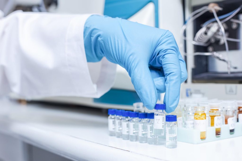 Professional laboratory worker holding tubes